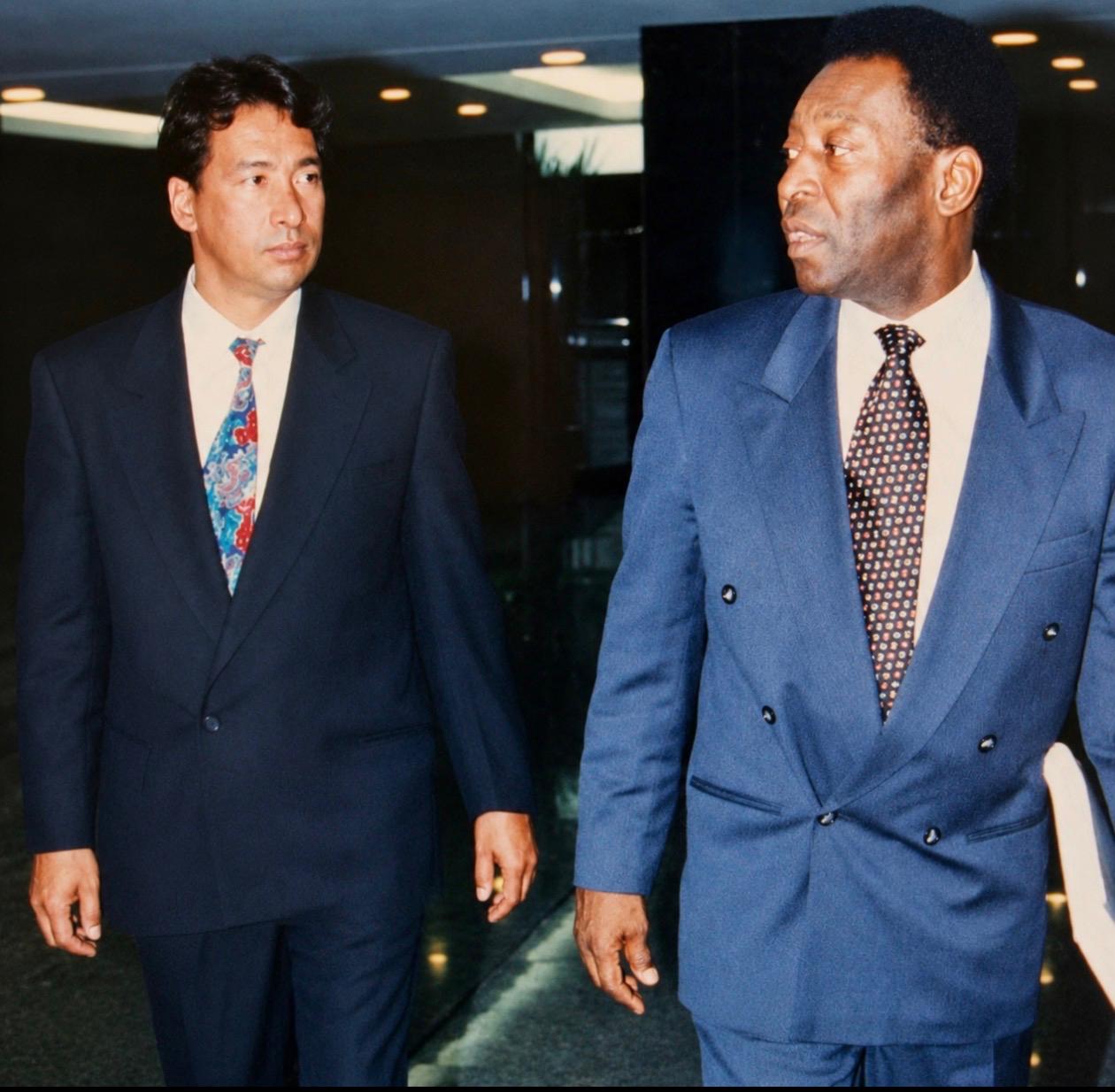 Hélio Viana de Freitas caminhando ao lado de Pelé